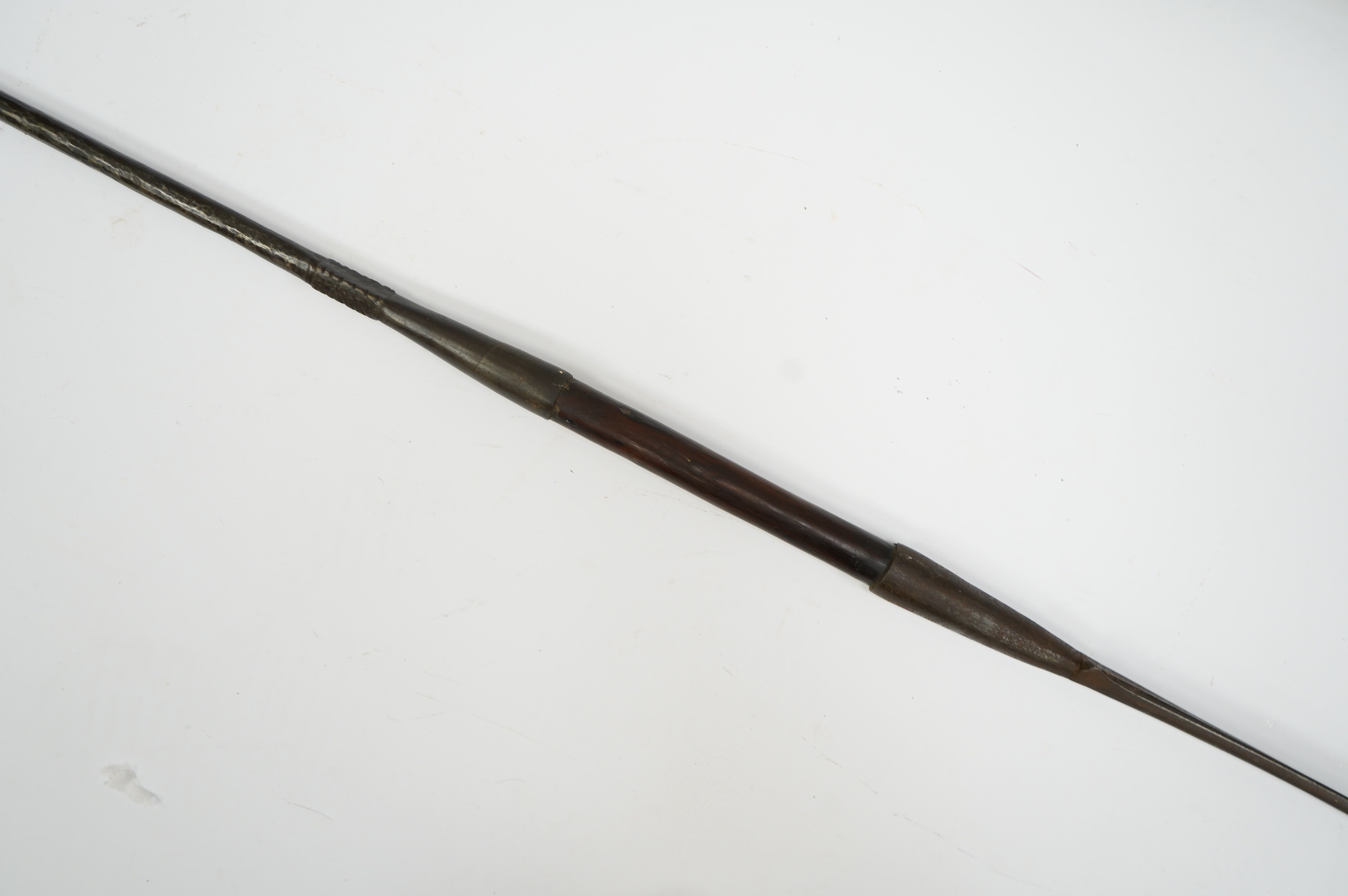 An African spear, with elongated iron tip and short hardwood shaft, 185cm. Condition fair to good, with patination.